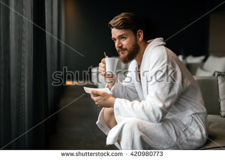 Male model drinking coffee in robe